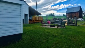 A rural property with a white building, a wooden deck, and a barn.