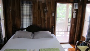A wooden room with a bed, a chair, and a window. - Sichang My Home (Ko Sichang)