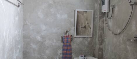 Ein Badezimmer mit Toilette, Waschbecken, Dusche und einem Handtuch an der Wand.