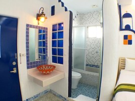 A bathroom with a white sink, a mirror, and a shower area.
