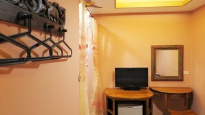 A small room with a TV, a wooden table, a mirror, and a ceiling light. - Sin Sin Hotel I (Hengchun)