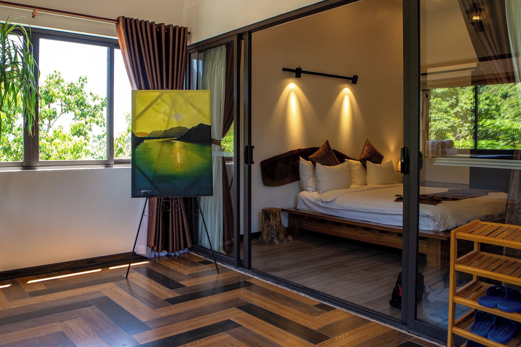 A modern room with a bed, a TV, and a large window with curtains.
