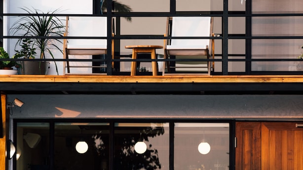 A modern building with large windows, a wooden deck, and a variety of plants. - Haku Beach Days Inn (Hengchun)