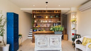 A spacious living area with a wooden bookshelf, a white sofa, and a blue cabinet. - Haku Beach Days Inn (Hengchun)