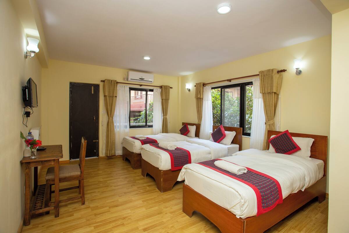 Habitación de hotel con dos camas, un escritorio y una silla.