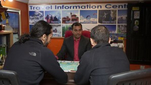 Eine Touristeninformation mit einer Pinnwand, die verschiedene Reiseaktivitäten zeigt.