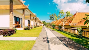 Une rangée de bâtiments de style traditionnel, avec des toits en tuiles, un chemin pavé et une végétation bien entretenue.
