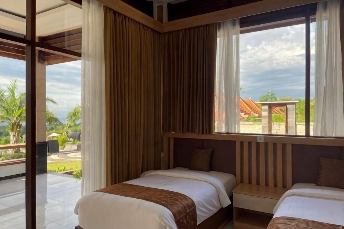 Una habitación con dos camas, un ventanal grande y vistas al exterior.
