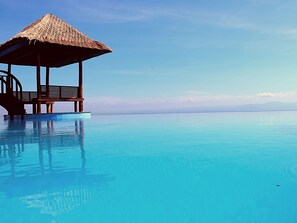An infinity pool with a wooden structure and a thatched roof. - Semabu Hills Hotel Nusa Penida - Bali (Penida Island)