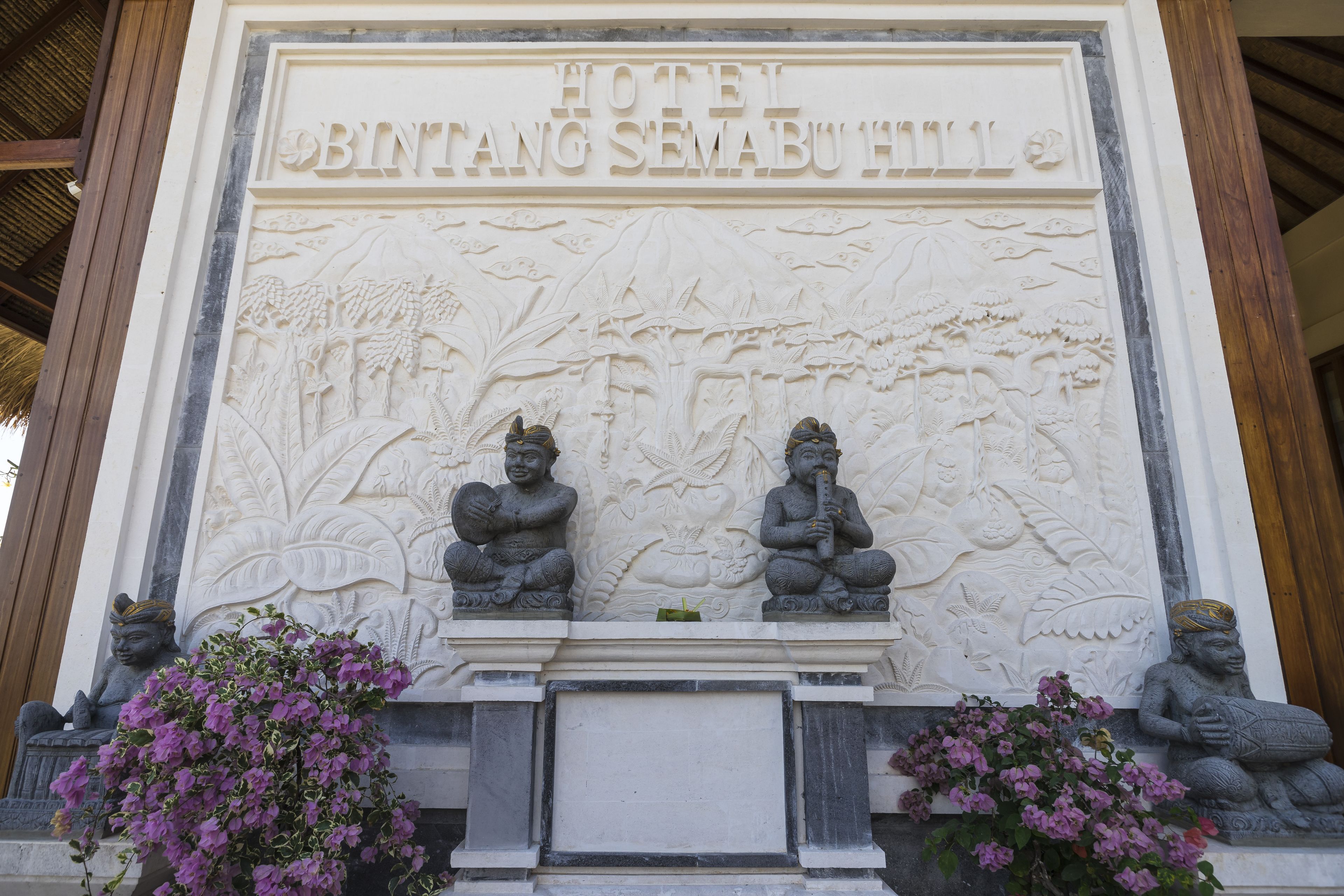 A carved relief with the text "HOTEL BINTANG SEMABU HILL" and two seated figures.