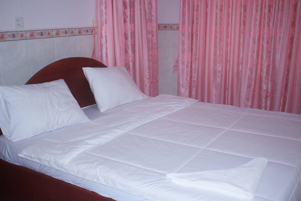 Een bed met witte beddengoed en een houten hoofdbord.