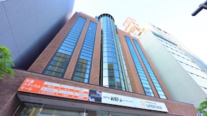 A tall building with a sign for Hotel WBF and a Fitness Club Lifestyle. - Hotel WBF Sapporo Odori (Sapporo)