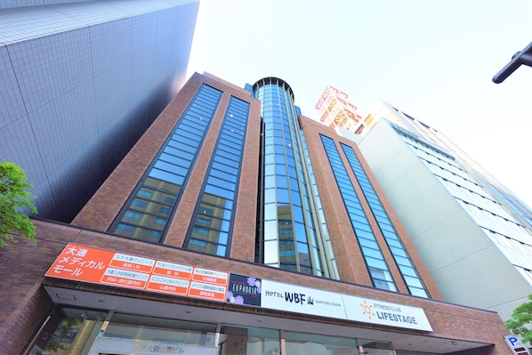 A tall building with a sign for Hotel WBF and a Fitness Club Lifestyle.