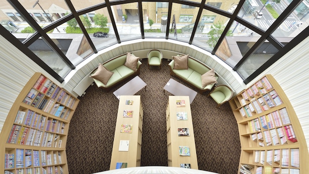 A library with a curved seating area and bookshelves. - Hotel WBF Sapporo Odori (Sapporo)