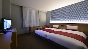 A hotel room with a large bed, a desk with a computer, a small table, and a window with curtains. - Hotel WBF Sapporo Odori (Sapporo)