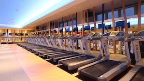 A row of treadmills in a gym with a modern design, large windows, and a ceiling with recessed lighting. - Hotel WBF Sapporo Odori (Sapporo)