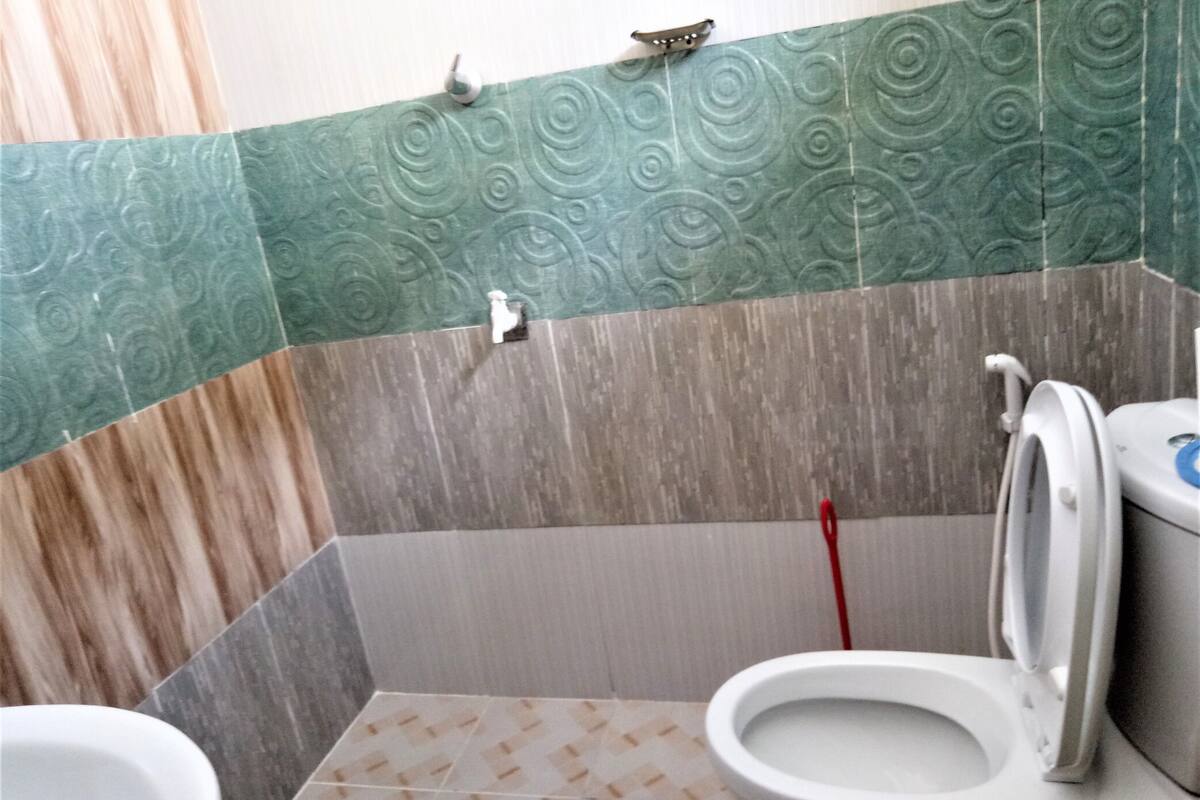 Un baño con inodoro, ducha y lavamanos.