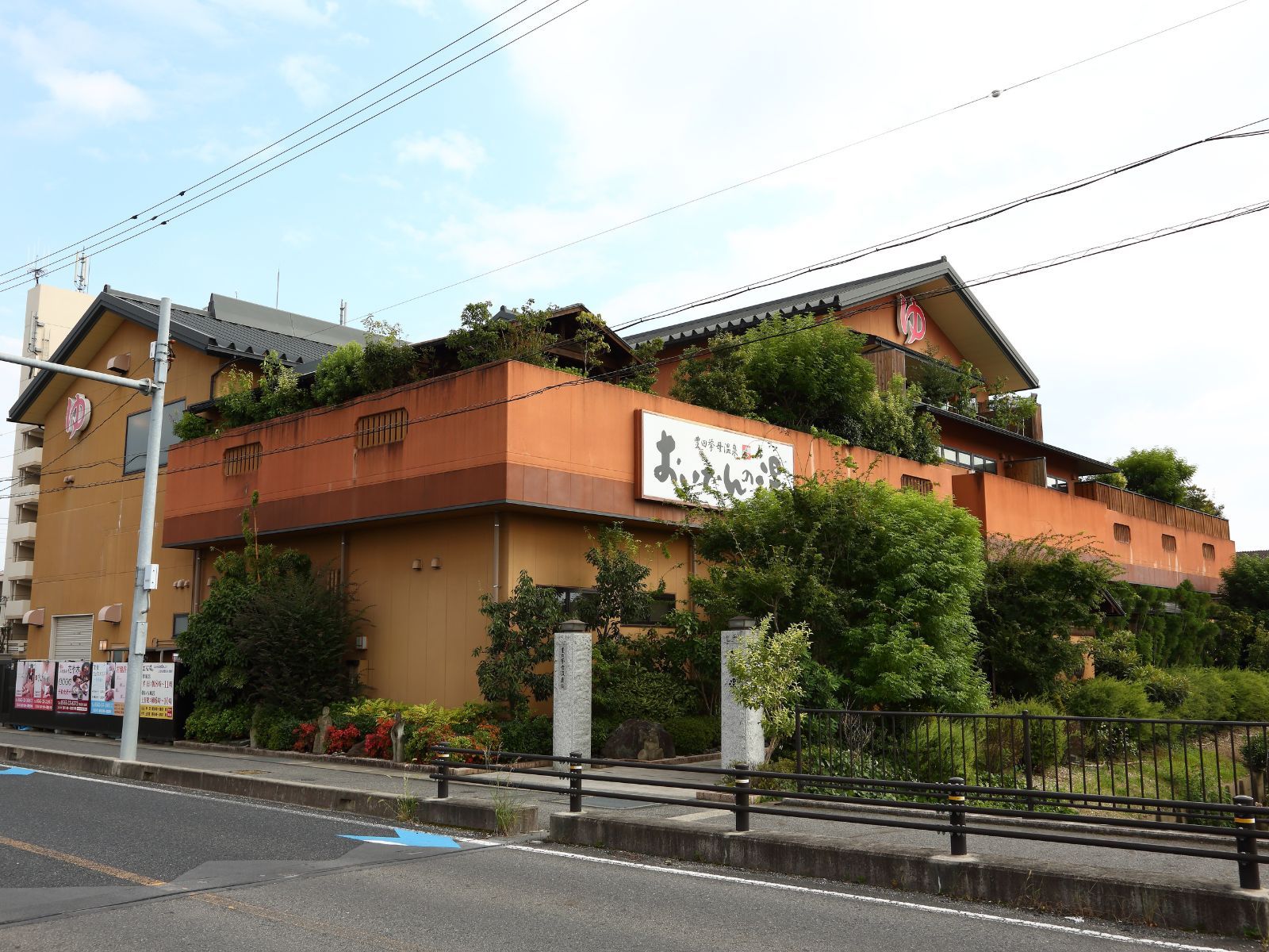 A multi-story building with a traditional architectural style, featuring a signboard with Japanese characters.