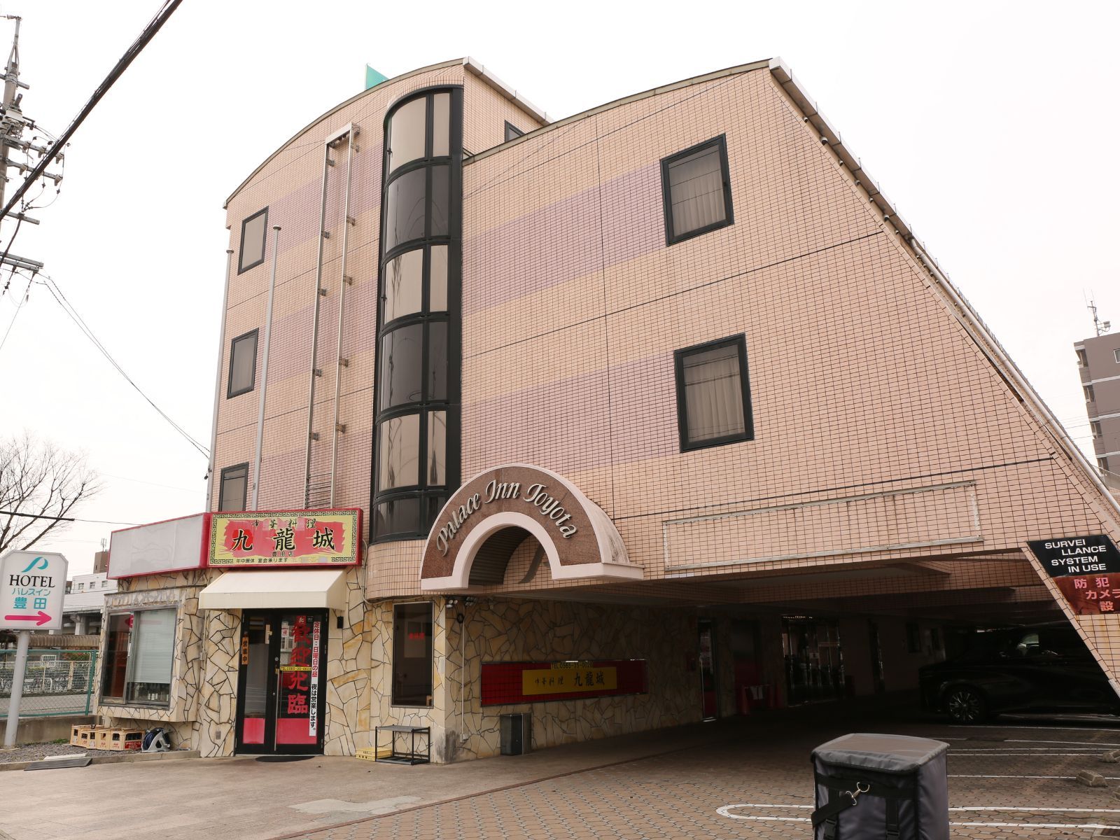 A hotel with a distinctive sloped roof and a sign for 'Palace Inn.'