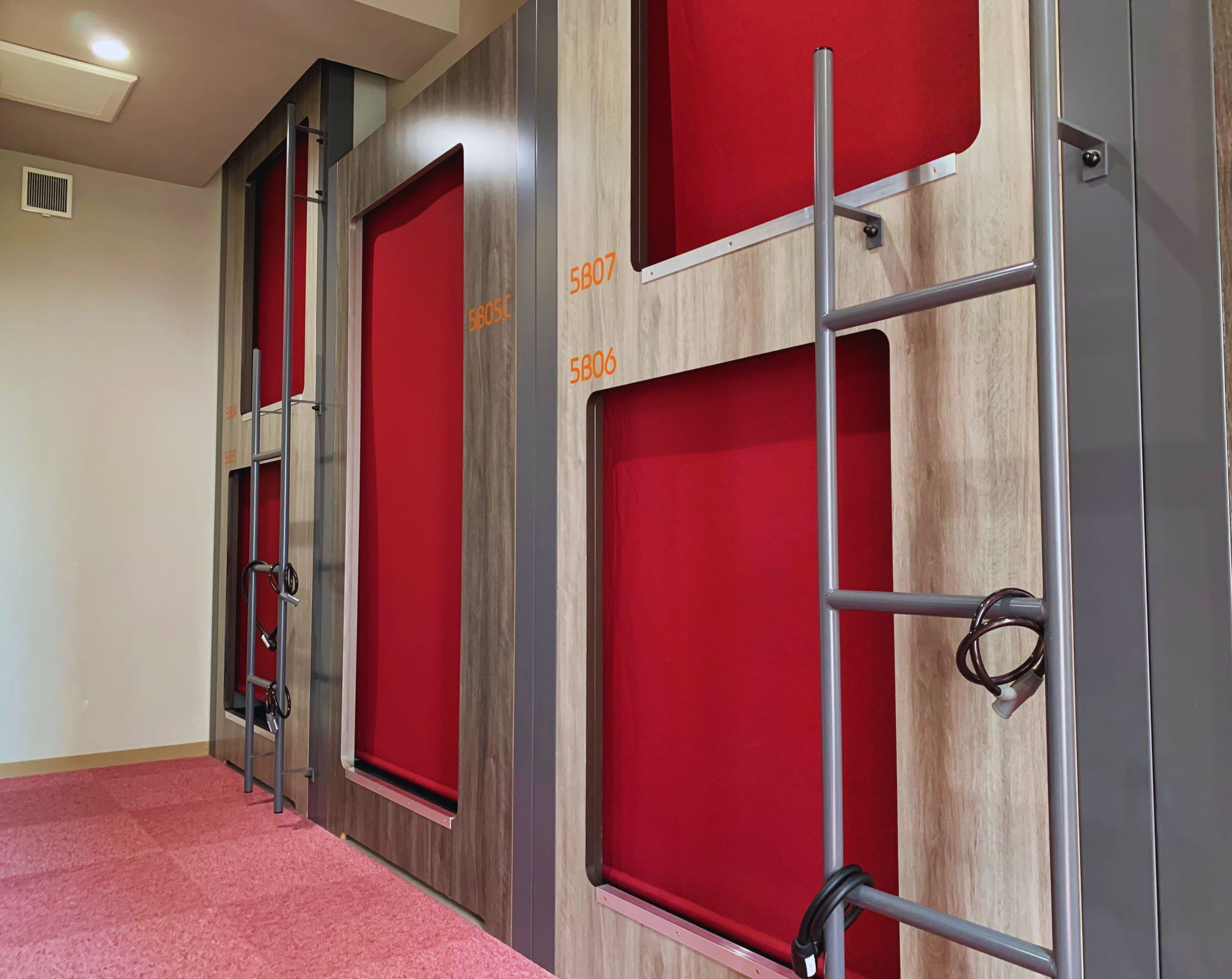 Fila de habitaciones de hotel con paneles de madera y detalles en rojo, con los números 5805C y 5806.