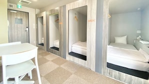 Una habitación de hotel con escritorio, una silla, una cama y un espejo.