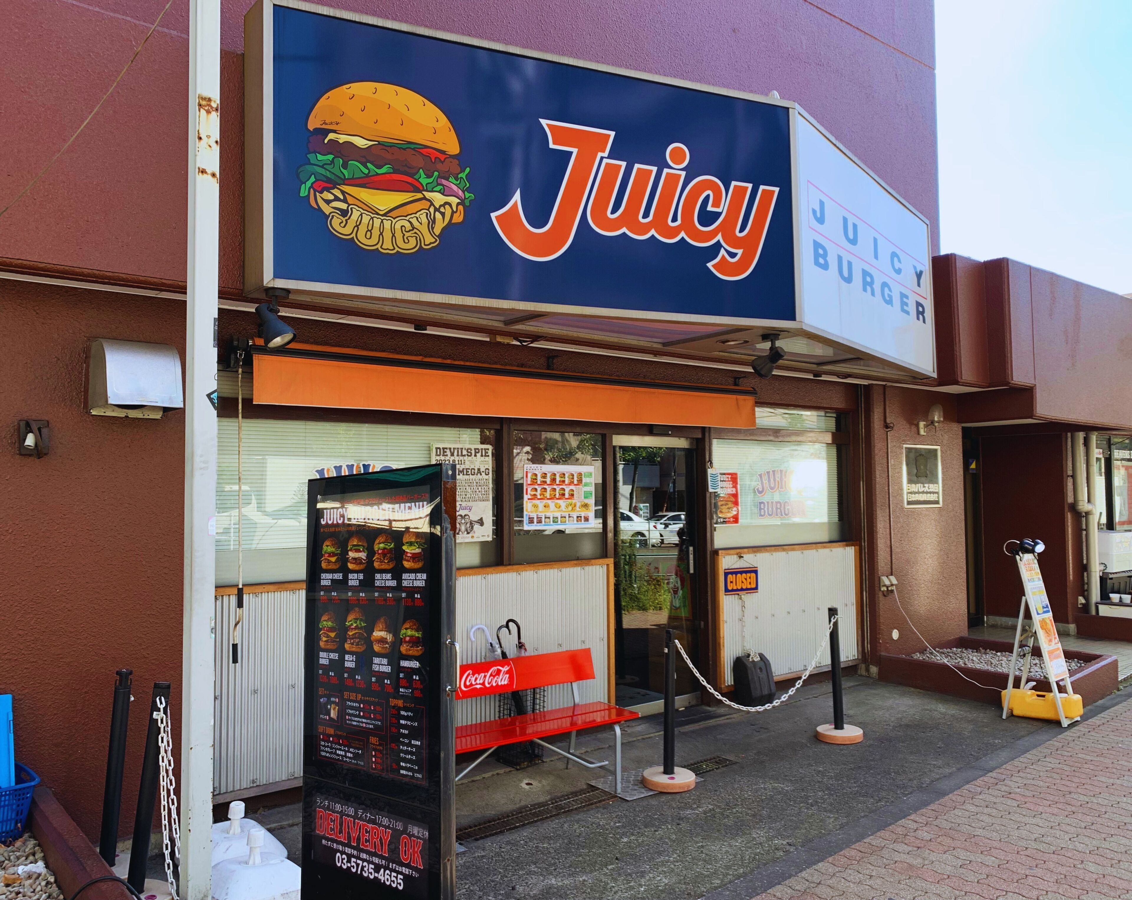 Juicy Burgers -niminen ravintola, jossa on ruokalista ja oviin kiinnitetty lappu, jossa ilmoitetaan, että se on suljettu.