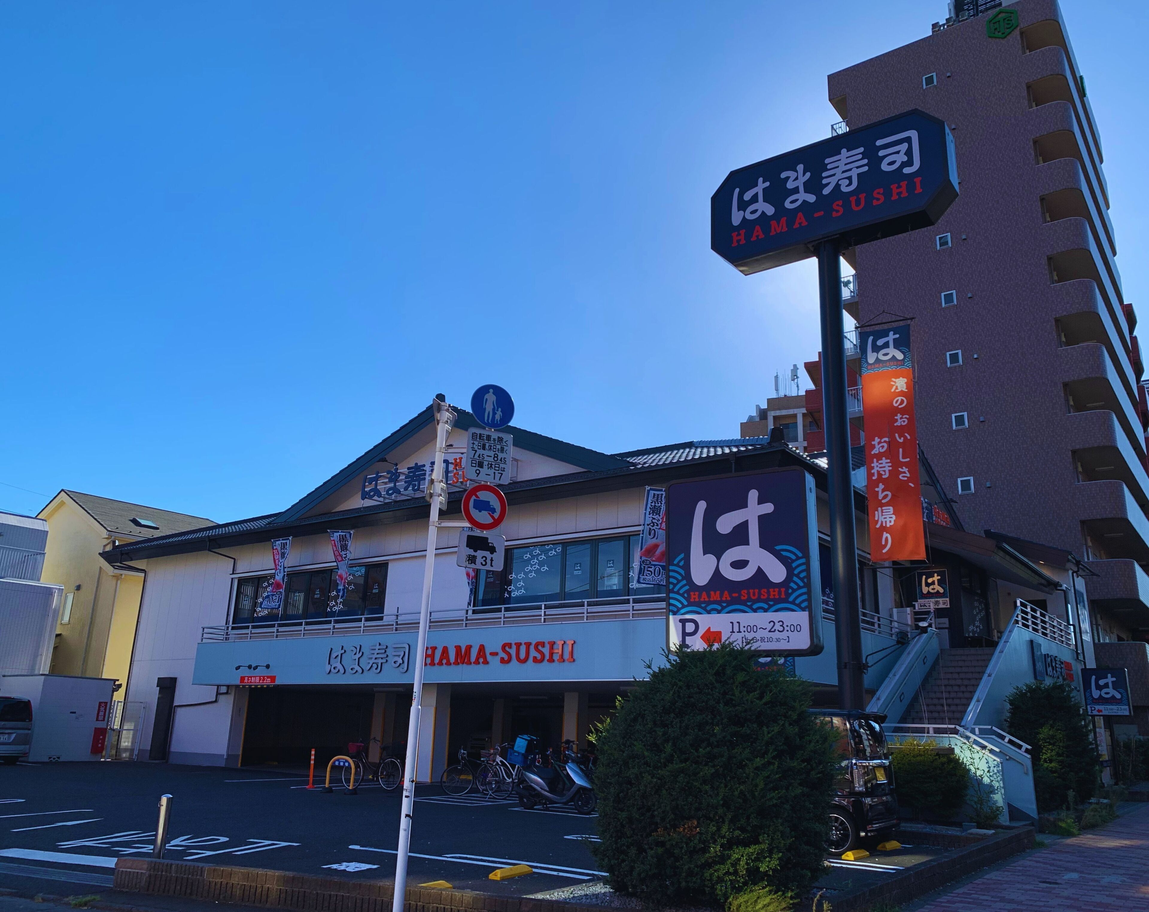 A building with a sign for HAMA-SUSHI restaurant.