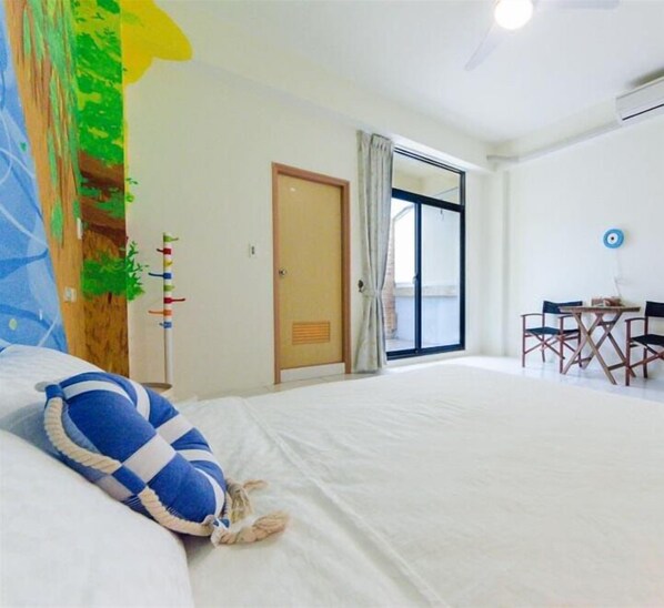 A hotel room with a bed, a desk with chairs, a door, and a window. - anping2x2 b&b (Tainan)