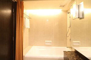 Une salle de bain avec une baignoire, une douche et un lavabo.