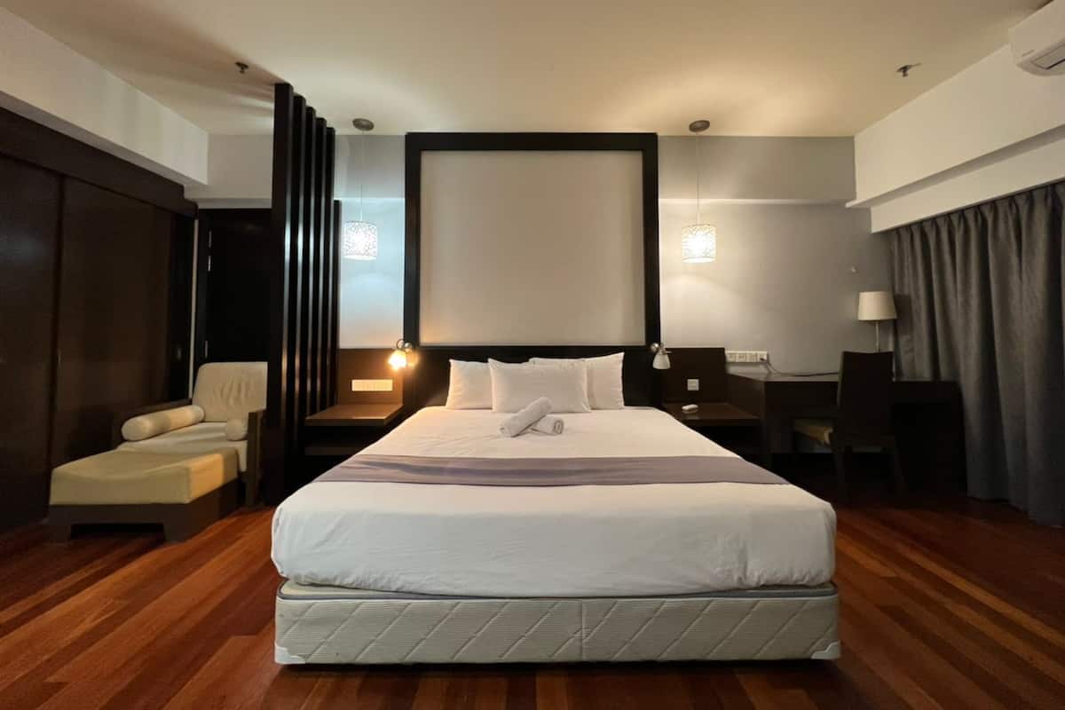 Une chambre d’hôtel avec un grand lit, un bureau, une chaise et un canapé.