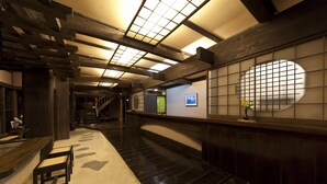 A traditional interior with wooden beams, tatami flooring, and a shoji screen. - Gokuraku Onsen Takumi No Yado (Takaharu)