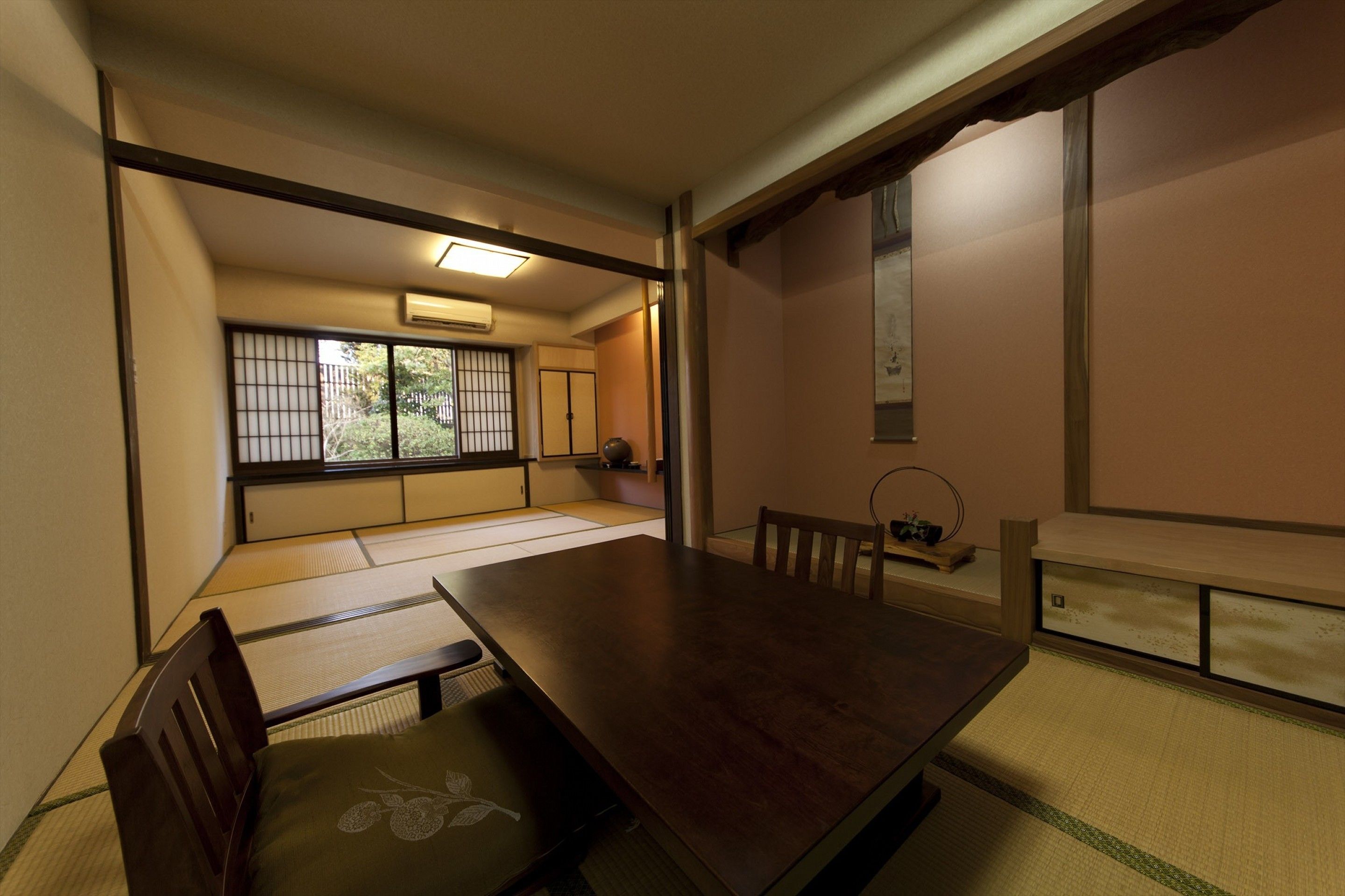 A traditional Japanese room with tatami flooring, a low table, and sliding doors.