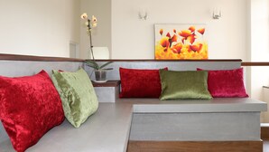 A seating area with a sofa and cushions in red, green, and red colors. - Golf Link Colombo (Colombo)