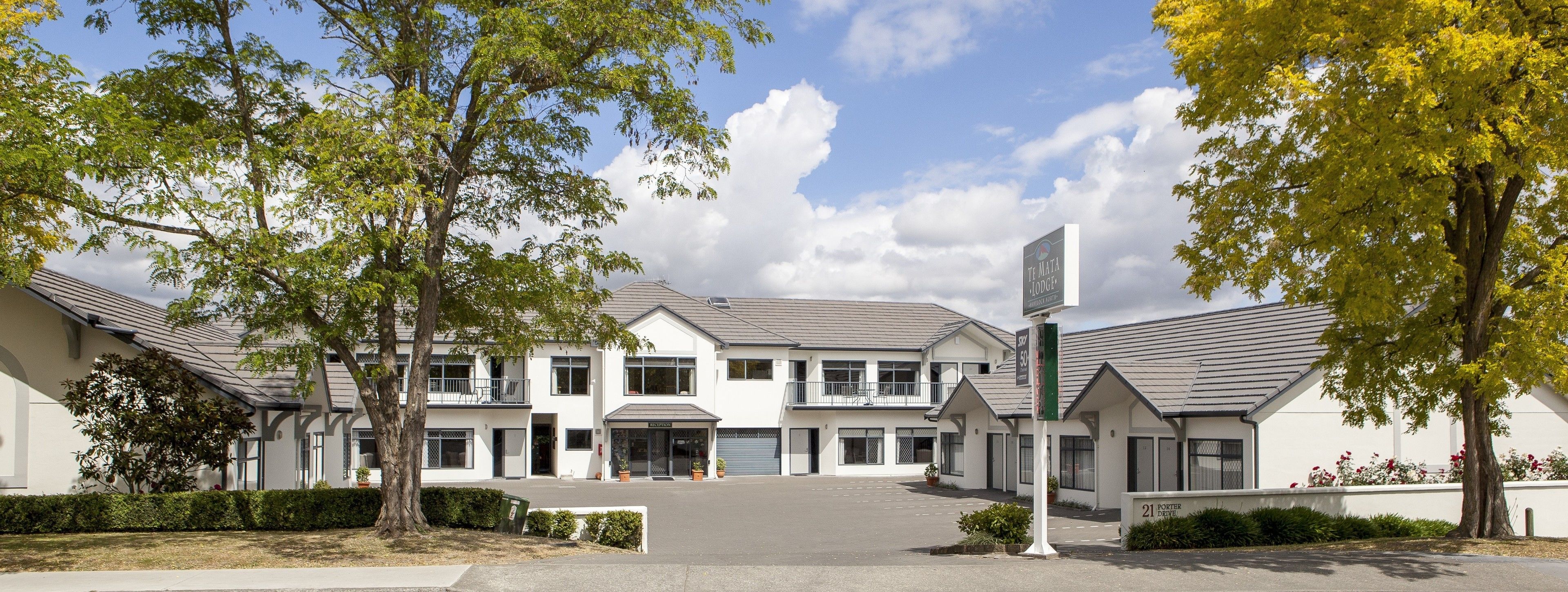 A white building with a sign reading "The Mata Lodge" and a sign indicating "21 Porter Drive".