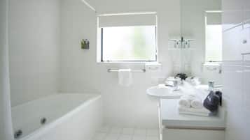 A modern bathroom with a bathtub, a sink, and a mirror.