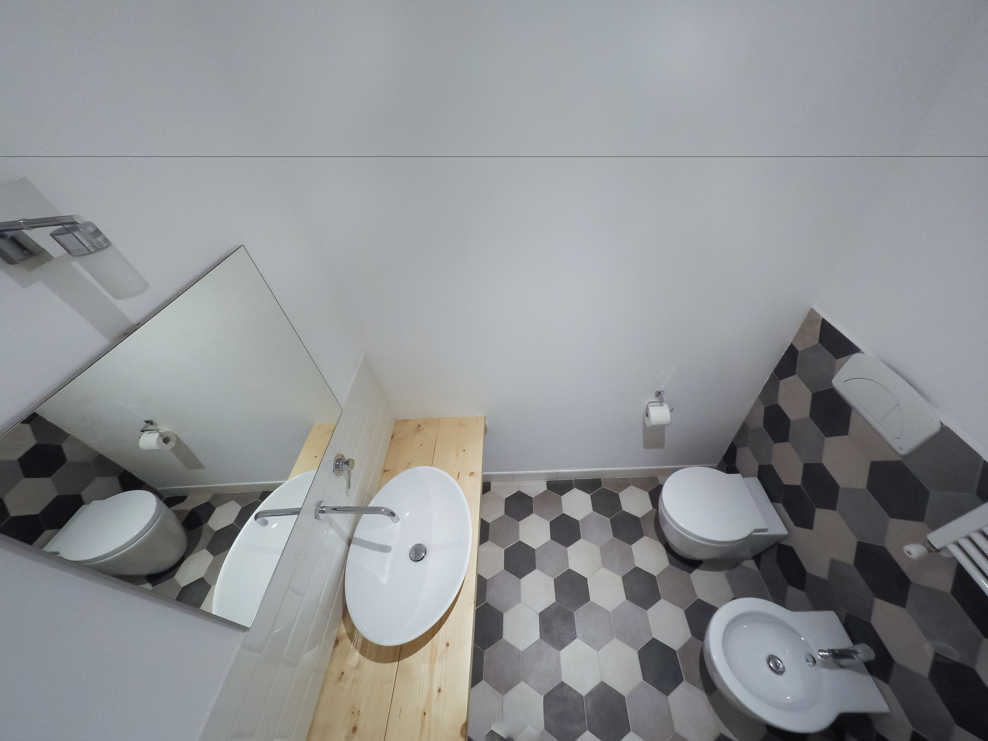 Une salle de bain moderne avec deux lavabos, des toilettes et un miroir.