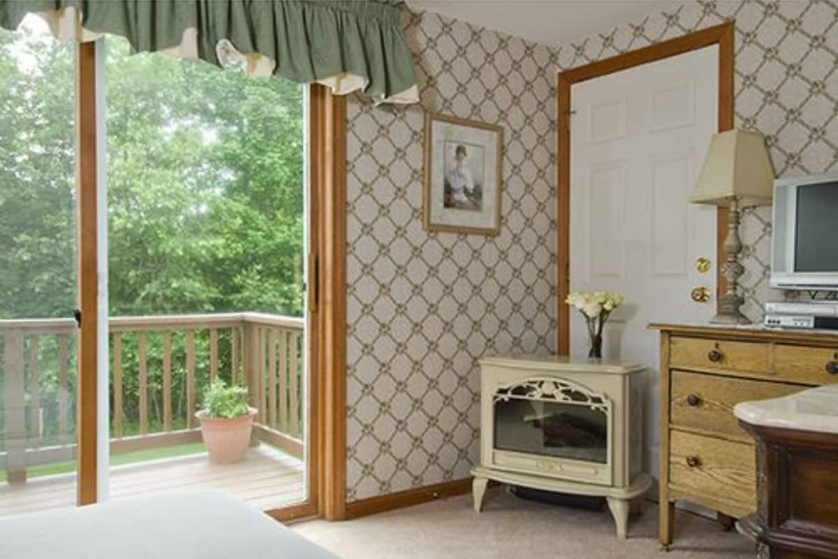 A room with a wooden deck, a vintage radio, and a television on a wooden cabinet.