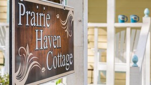 Uma placa de madeira com o texto 'Prairie Haven Cottage'.