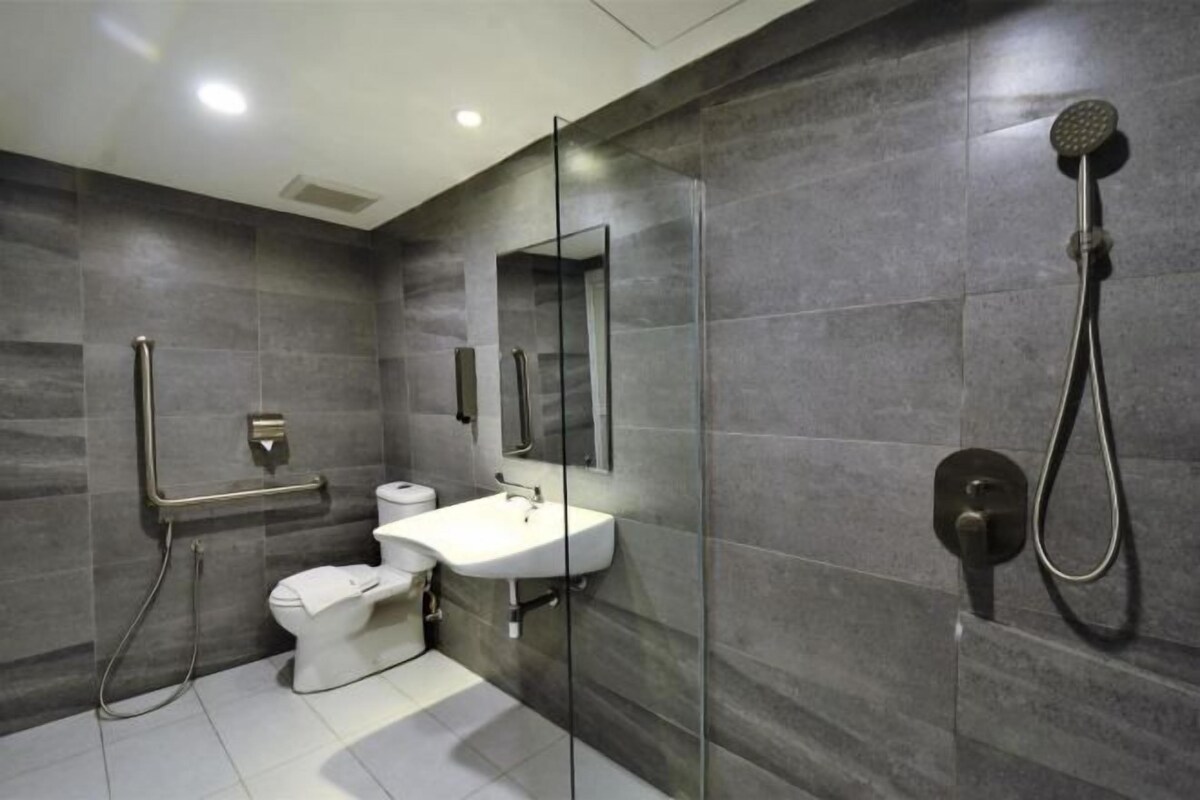 A modern bathroom with a glass shower enclosure, a white sink, and a toilet.