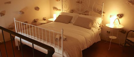 Un dormitorio con cama, mesitas de noche y una silla.