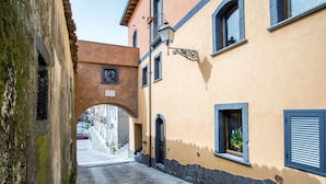 A narrow street with stone walls and a small archway. - L'Arco dei Sogni (Malvagna)