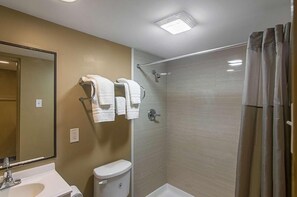 A bathroom with a shower, toilet, and sink.