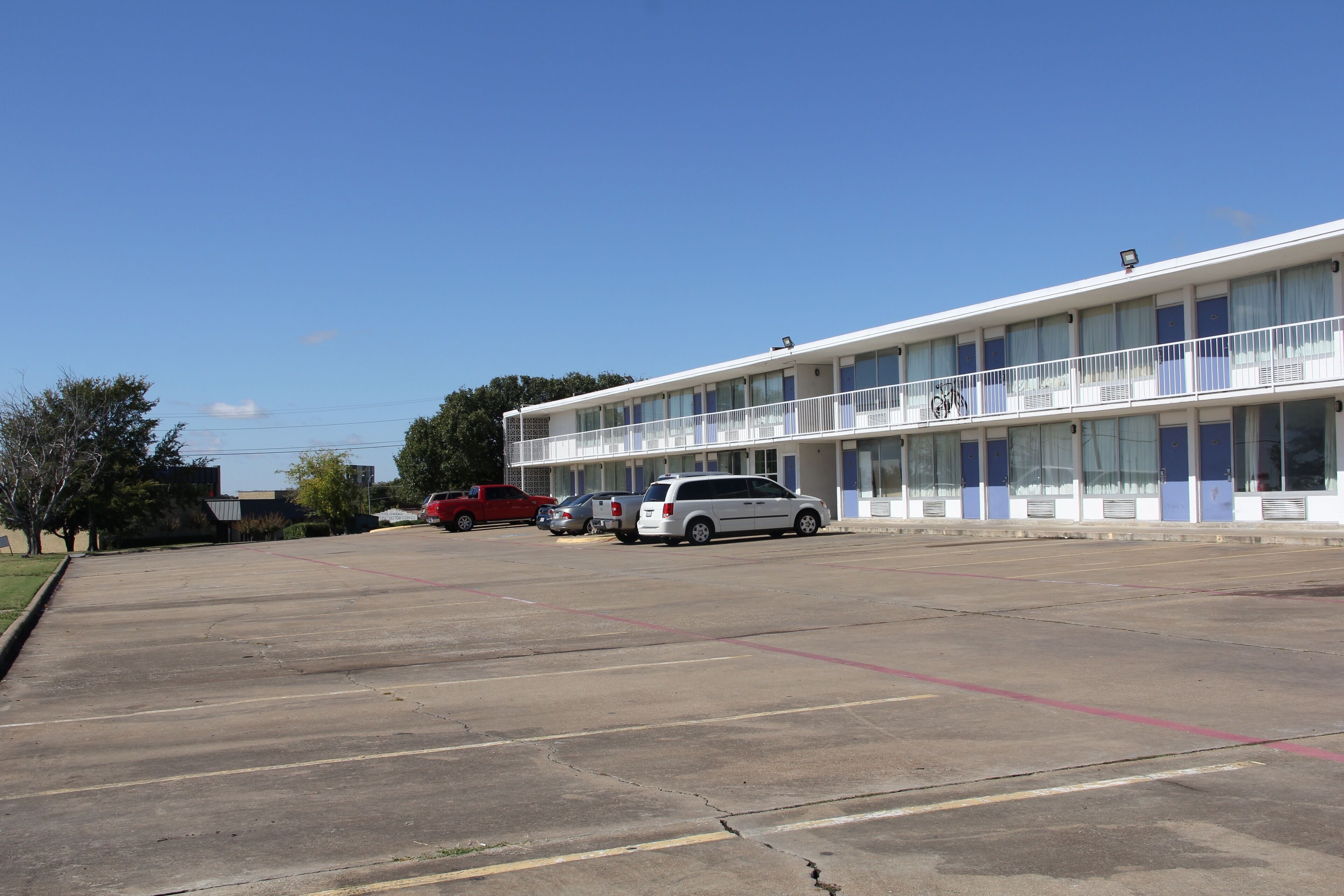 Un motel de varios pisos con estacionamiento.