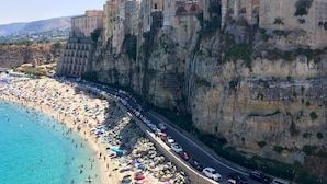 A coastal town with buildings built into cliffs overlooking a beach. - Palazzo Mottola Tropea (Tropea)