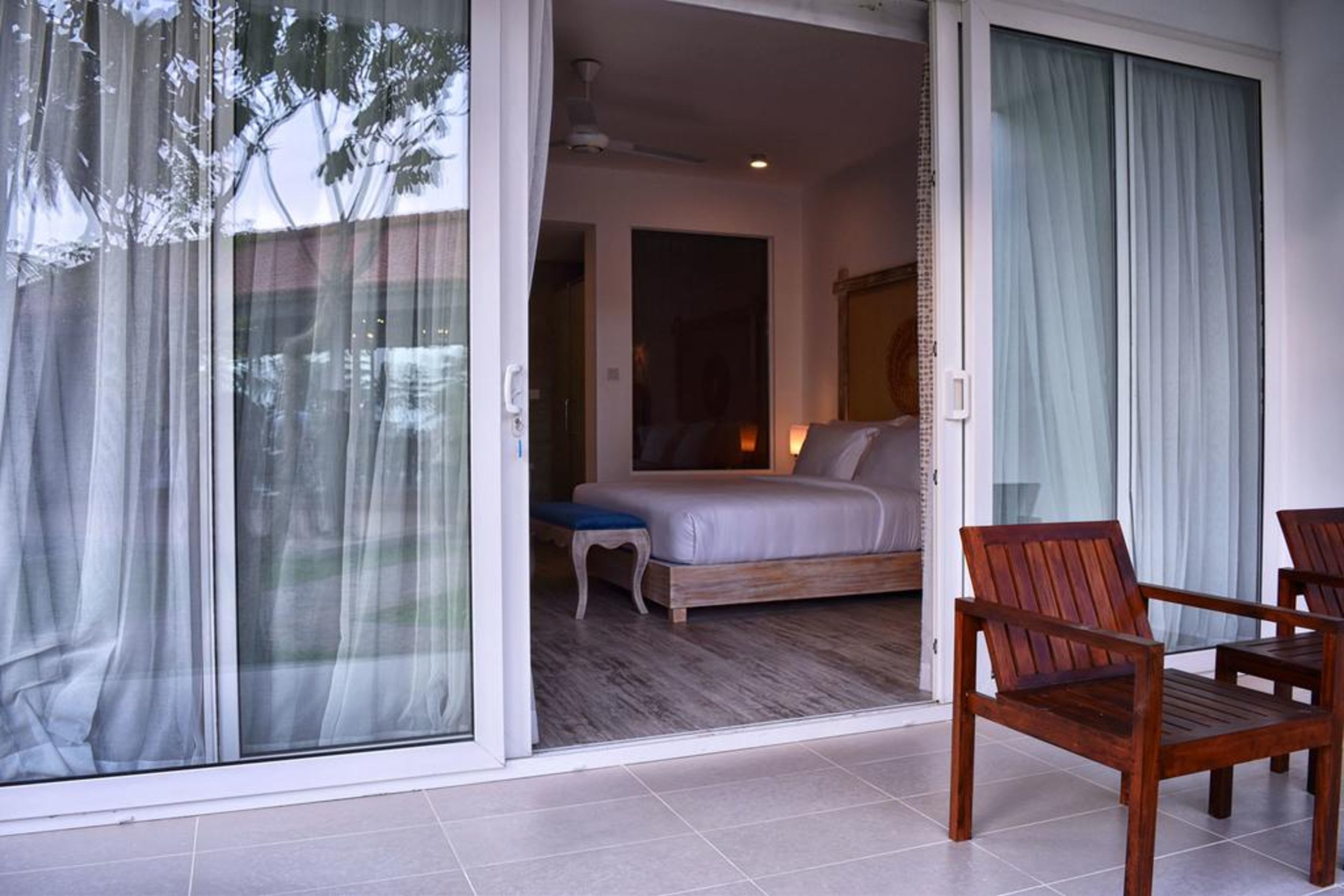 A bedroom with a bed, a nightstand, and a chair.