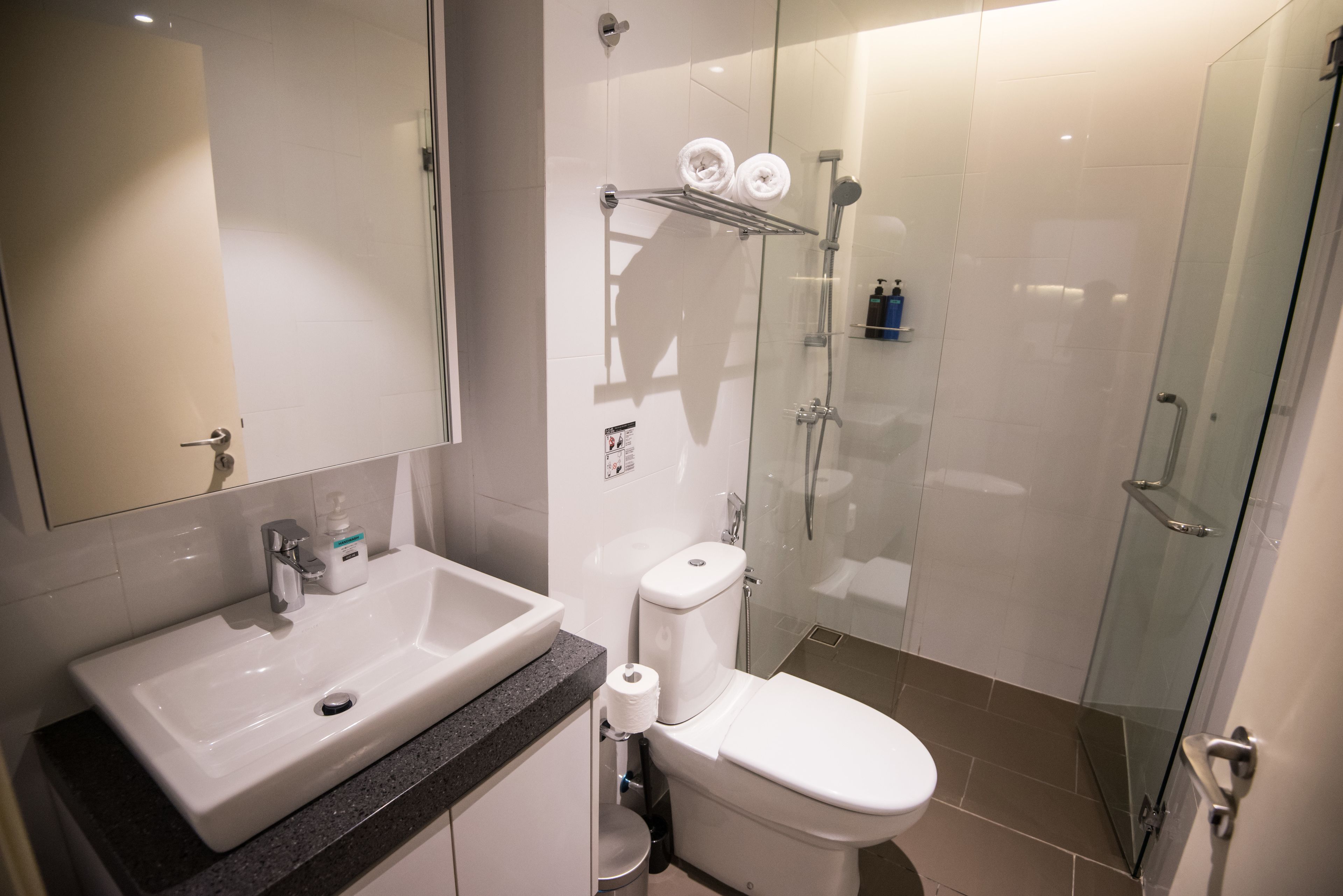 A modern bathroom with a sink, toilet, and glass-enclosed shower.