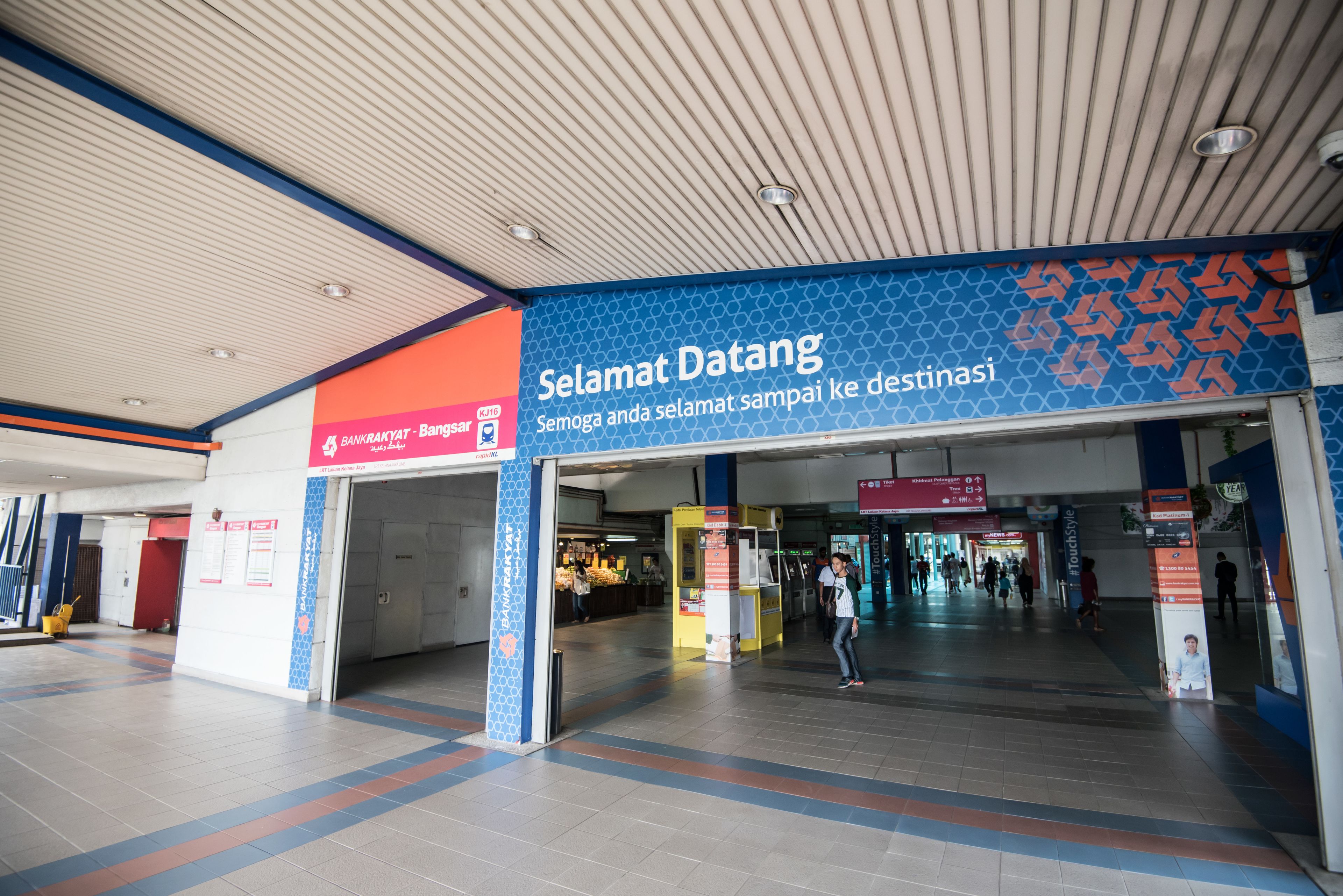 A spacious indoor area with a blue and orange sign reading "Selamat Datang" and "Bank Rakyat - Bangsar."
