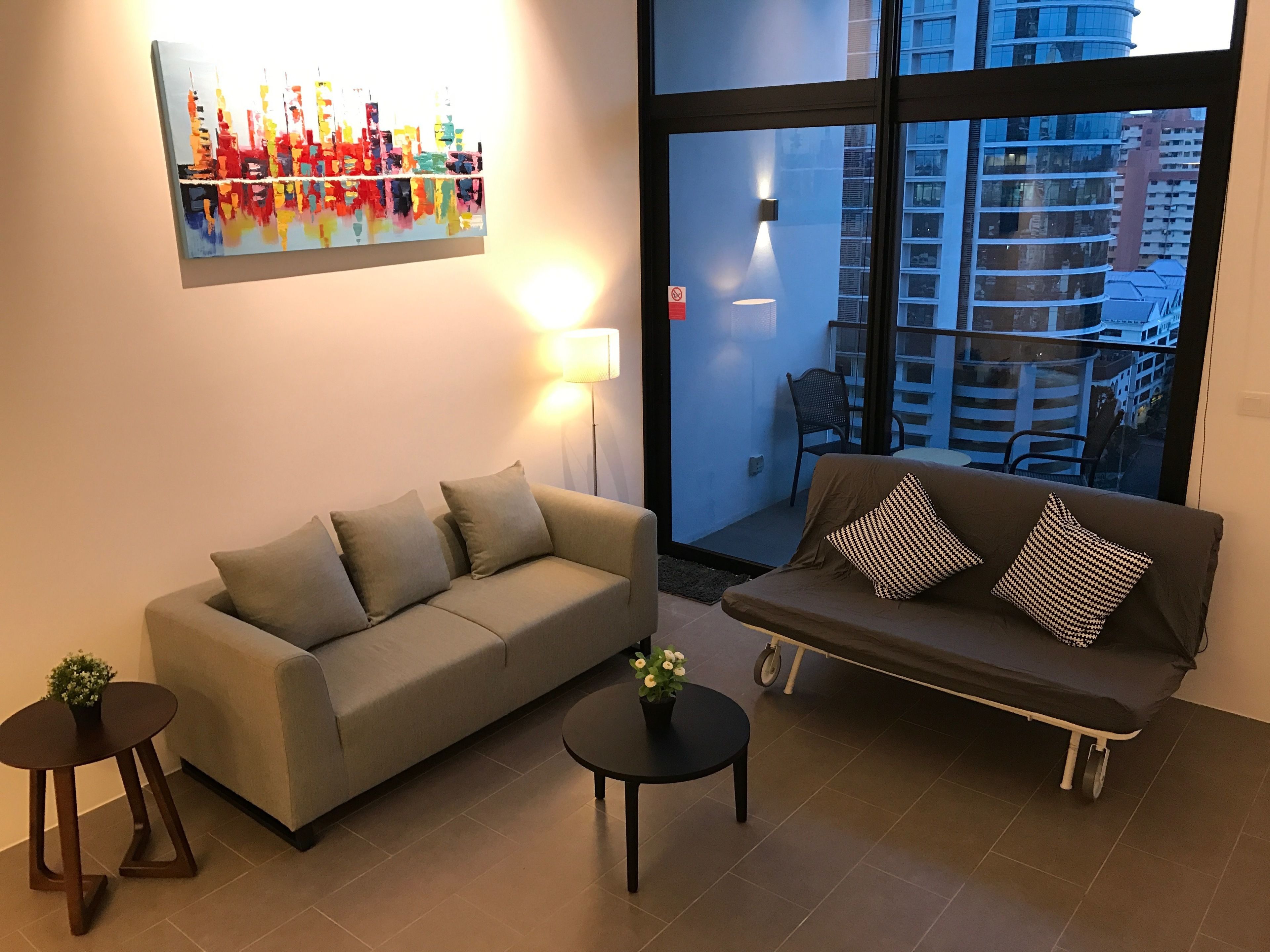 A living room with two sofas, a coffee table, and a painting on the wall.