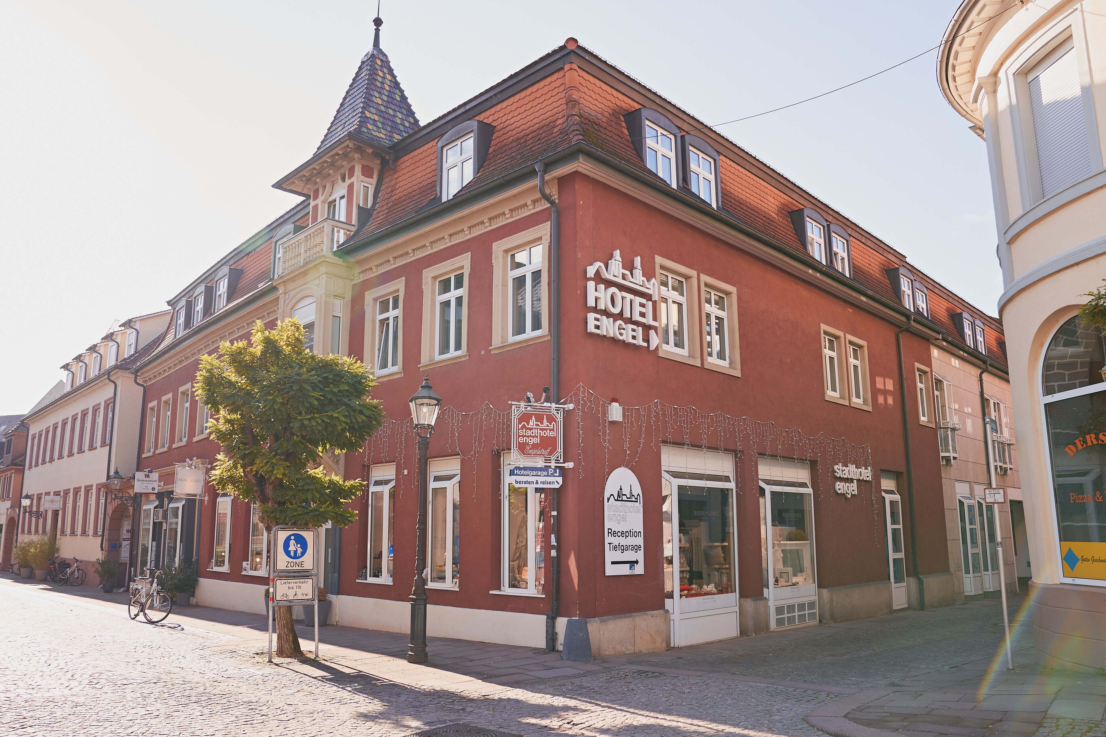 A red building with a sign for Hotel Engel.