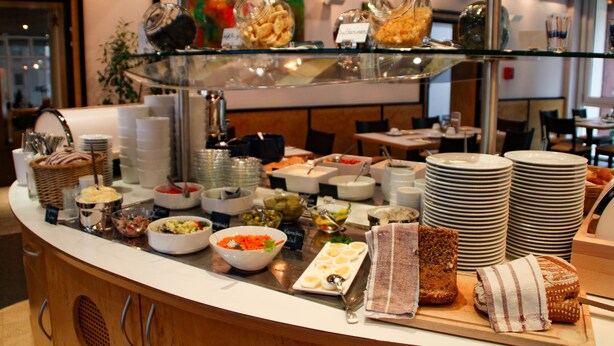 A buffet with various food items and dishes, including bowls of salad, plates of eggs, and containers of dips. - Stadthotel Engel (Ettlingen)
